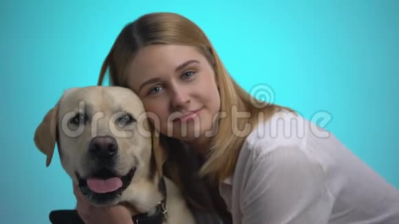 微笑的女人拥抱可爱的拉布拉多犬看着相机宠物是最好的朋友视频的预览图