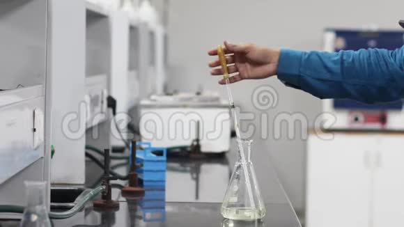 在化学实验室用手从装有玻璃吸管的锥形瓶中取出一种化学物质视频的预览图