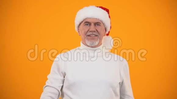 圣诞老人帽子里带着公寓钥匙的兴奋的退休男视频的预览图