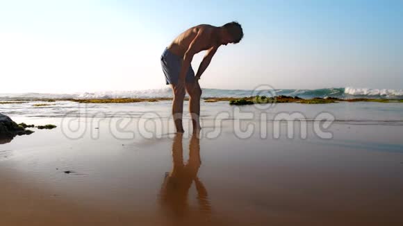 运动员在潮湿的沙滩上沉思视频的预览图