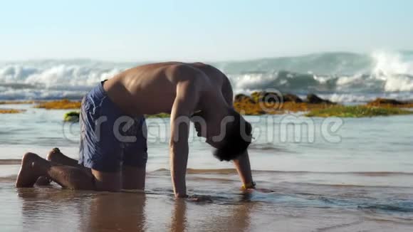 英俊的运动员在无尽的海洋附近练习瑜伽视频的预览图