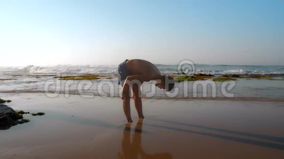 有经验的运动员站在潮湿的沙滩上反射着轮廓视频的预览图