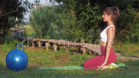 大自然中的瑜伽年轻迷人的瑜伽女孩在绿草中冥想和做瑜伽练习视频的预览图