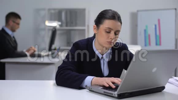 无聊的女经理在笔记本电脑上发短信拖延问题避免工作视频的预览图