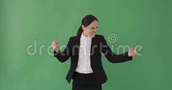 兴奋的女商人在绿色背景下跳舞视频的预览图