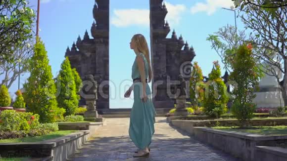 慢镜头年轻女性游客参观印度尼西亚巴厘岛的梵天维哈拉阿拉姆寺巴厘岛旅行视频的预览图