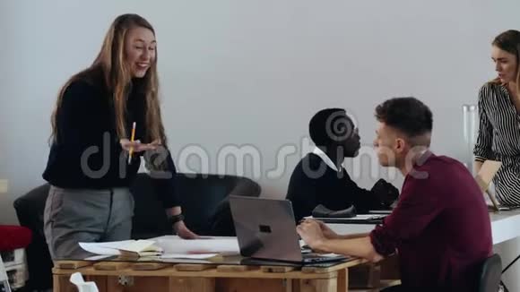 快乐年轻的金发碧眼老板商业女性在现代办公桌上激励男性经理多民族背景的员工视频的预览图