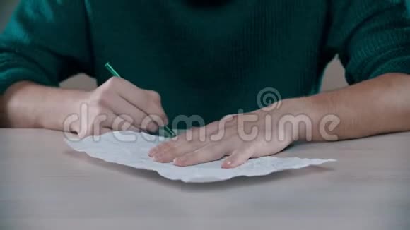 一个男人正在皱巴巴的纸上写字视频的预览图