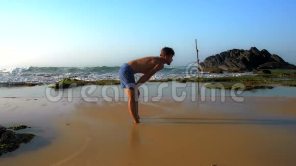 运动员双手跪立在潮湿的沙滩上视频的预览图