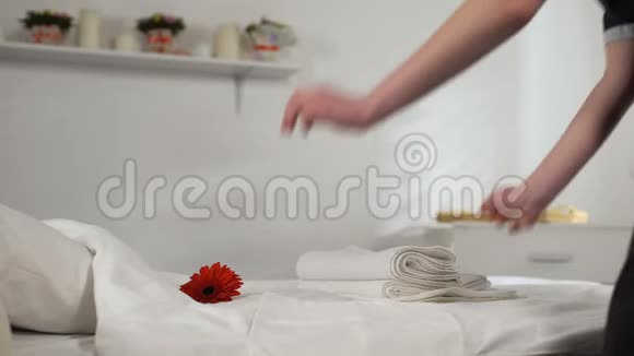 年轻女佣折叠和带走毛巾为客人清洁酒店房间视频的预览图