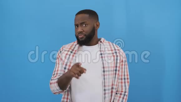 年轻的非裔美国人穿着休闲衬衫站在白色的背景上做着快乐的竖起大拇指的手势视频的预览图