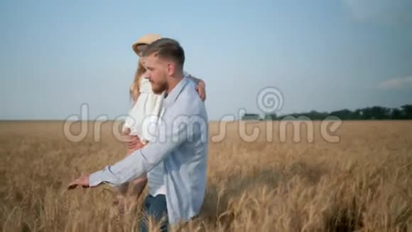 父母与孩子的关系年轻的爸爸带着微笑的女儿走着手拿着小麦穗滑下视频的预览图