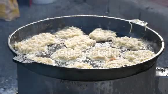 在外面的大煎锅里放土豆煎饼视频的预览图