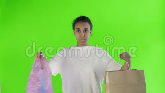 非洲裔美国女活动家在彩色关键背景上选择纸和塑料袋视频的预览图