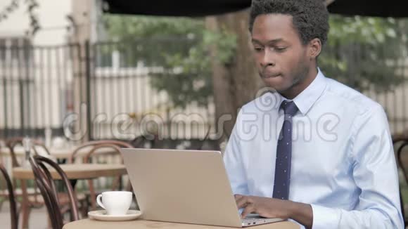 户外咖啡厅使用笔记本电脑的非洲商务人员视频的预览图