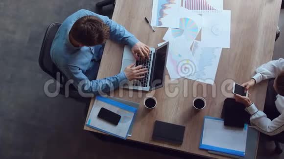 商人用手机输入笔记本电脑的数据视频的预览图