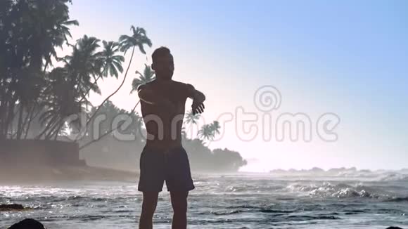 强壮的体操运动员与棕榈树的轮廓握手视频的预览图