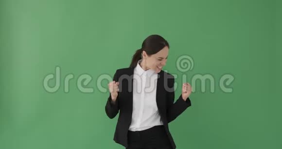 兴奋的女商人在绿色背景下跳舞视频的预览图