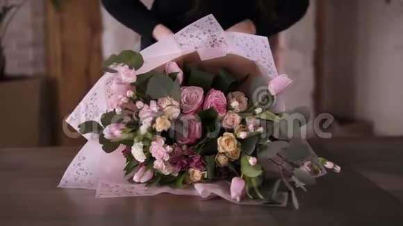最后的接触女花店把花带系在她准备好的花束上颜色为粉红色糊状喜欢她的工作慢慢视频的预览图