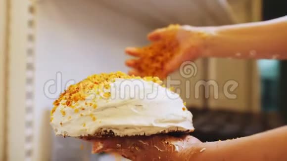 糖果师在面包店的特写镜头中用碎块装饰蛋糕视频的预览图