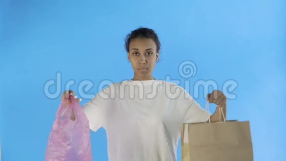 非洲裔美国女活动家在蓝色背景下选择纸和塑料袋视频的预览图