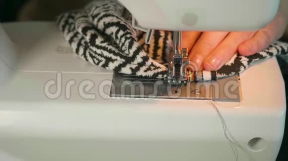 在电动缝纫机中女士的手缝织物视频的预览图