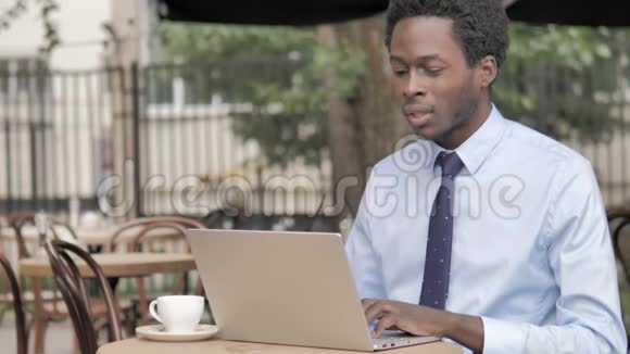非洲商务人士颈部疼痛使用笔记本电脑户外视频的预览图