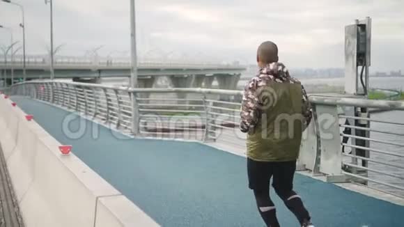 非洲男子在城市的人行桥上慢跑视频的预览图