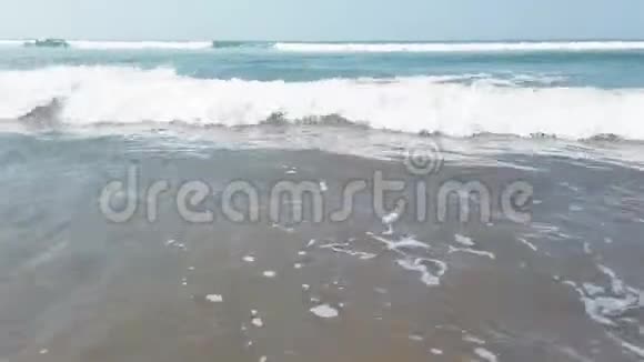 岸上的泡沫海波度假胜地阳光明媚的一天干净的海水在潮湿的沙滩上翻滚视频的预览图