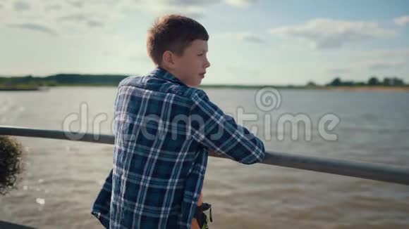 小男孩站在河边的码头上视频的预览图
