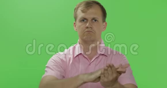 英俊的年轻人穿着粉红色衬衫拍手铬键视频的预览图