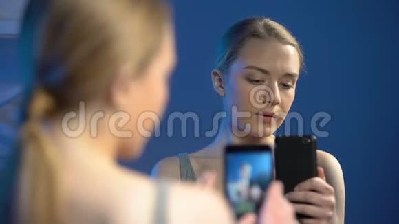 女青少年用智能手机对着镜子自拍美女博主视频的预览图