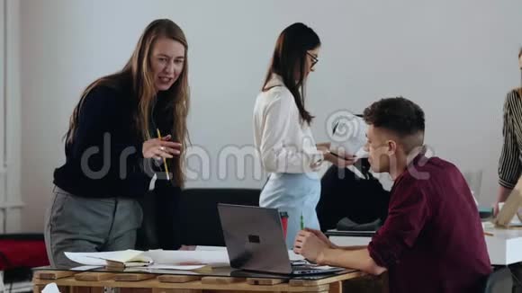 快乐的年轻职业金发商务女性与男性经理在笔记本电脑上交谈现代轻办公职场视频的预览图