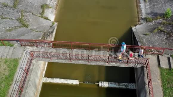 成人和儿童旅行一家人在废弃的大坝桥上散步视频的预览图