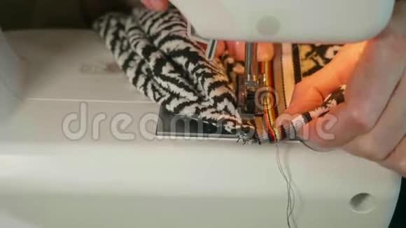 在电动缝纫机中女士的手缝织物视频的预览图