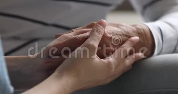 年轻女性手握老奶奶手臂的特写镜头视频的预览图