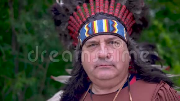 美洲印第安人以严肃的面孔站在森林的背景下视频的预览图