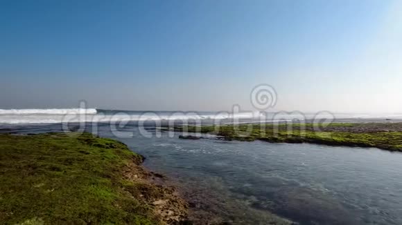 巴厘岛美丽的海滩景观阳光明媚的蓝天背景下海浪拍打着视频的预览图