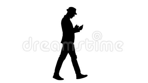 剪影严肃的阿拉伯休闲男子使用智能手机边走视频的预览图
