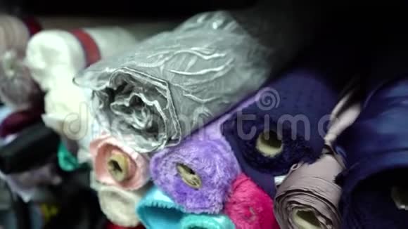 年轻的女性手触摸一堆时髦的织物卷视频的预览图