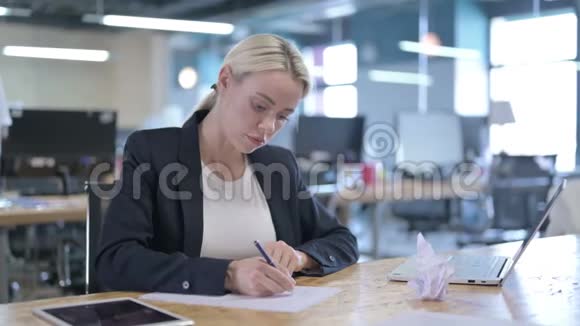 勤劳的女商人在办公室写论文视频的预览图