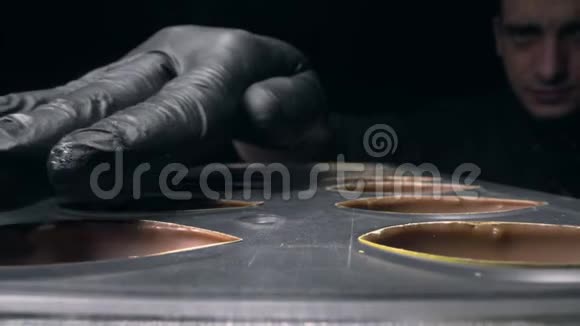 巧克力师纠正和准备巧克力模具以填充不同口味制作糖果和手工制作视频的预览图