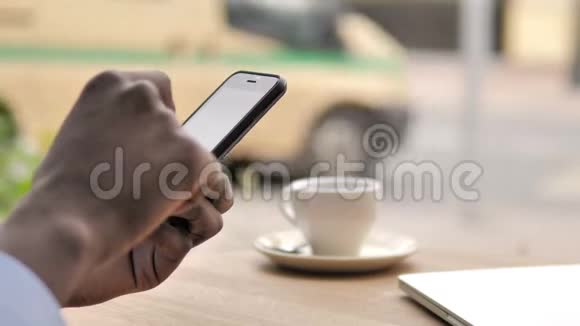 户外咖啡厅使用智能手机的非洲手视频的预览图