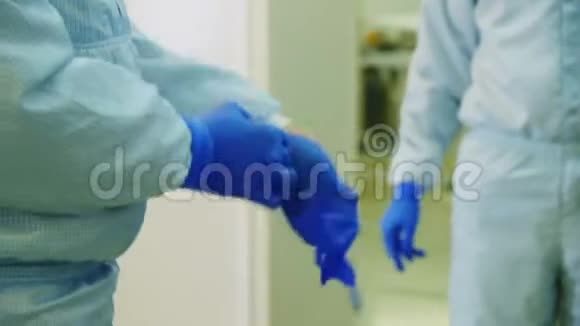 员工在车间储物柜里戴上蓝色橡胶手套视频的预览图