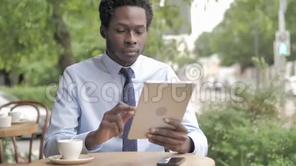 非洲商人在桌上庆祝胜利坐在室外咖啡厅视频的预览图