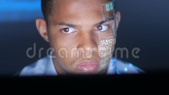 程序员或黑客寻找监控软件代码反映在他的脸上一个黑人男人在黑暗的房间里视频的预览图