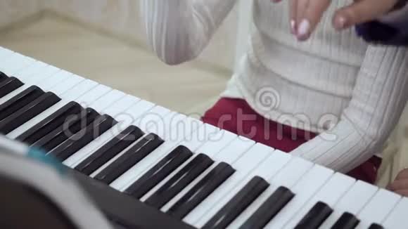 近距离观看儿童的手在钢琴上演奏视频的预览图