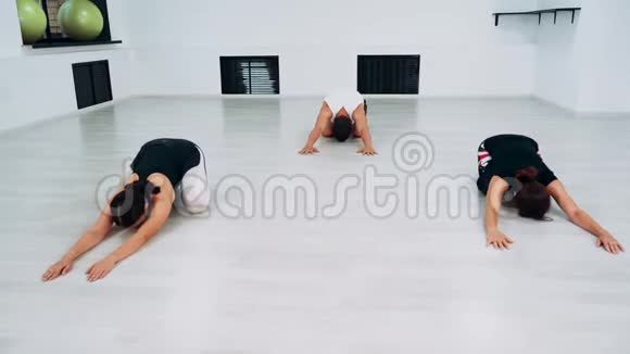 一组三个人在健身后做伸展运动眼镜蛇波塞视频的预览图