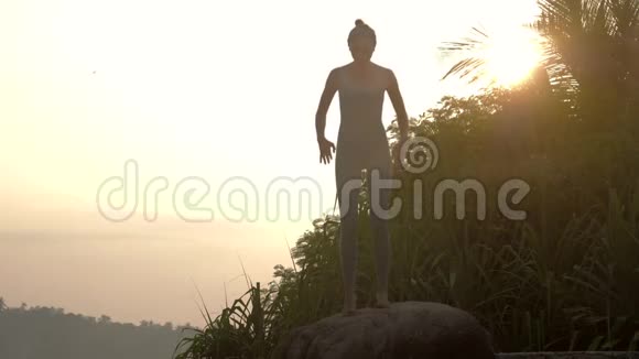 女孩在旧石上做瑜伽运动早晨慢动作视频的预览图
