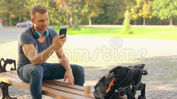 快乐的男人在公园里发短信视频的预览图